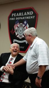 Smith gets a congratulatory handshake from Commissioner Stacy Adams.